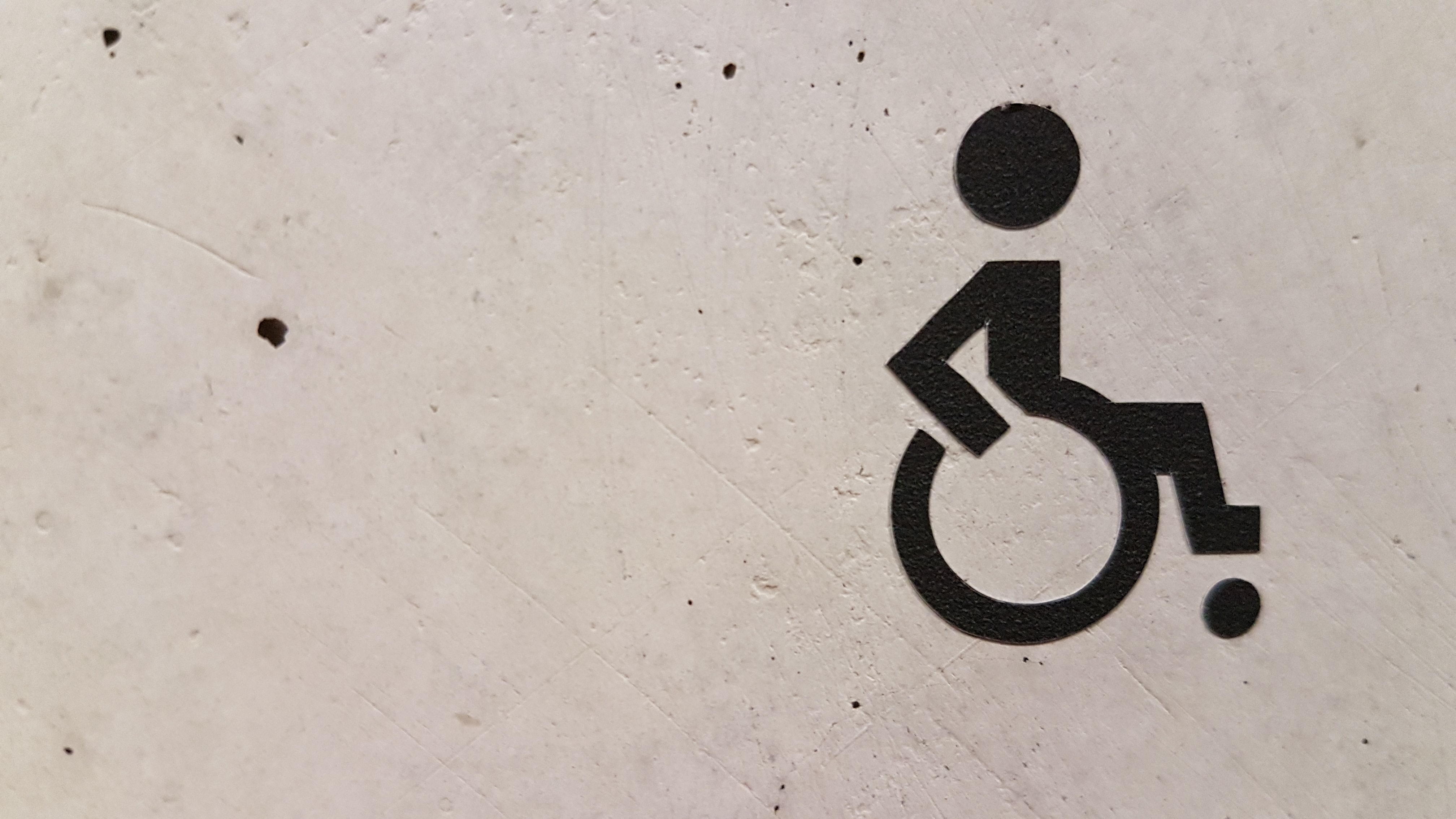 Pictogramme d'une personne en fauteuil roulant sur un mur